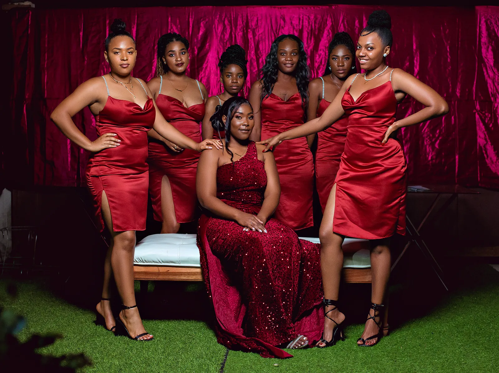 Aniversariante sentada com as amigas de vestidos vermelhos